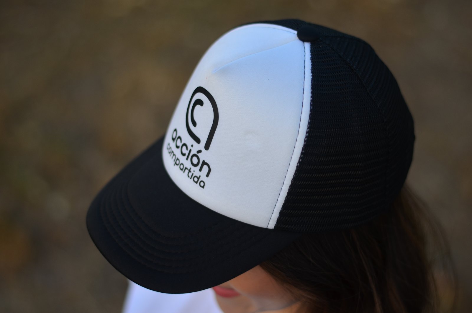 Gorra con el logo de Acción Compartida