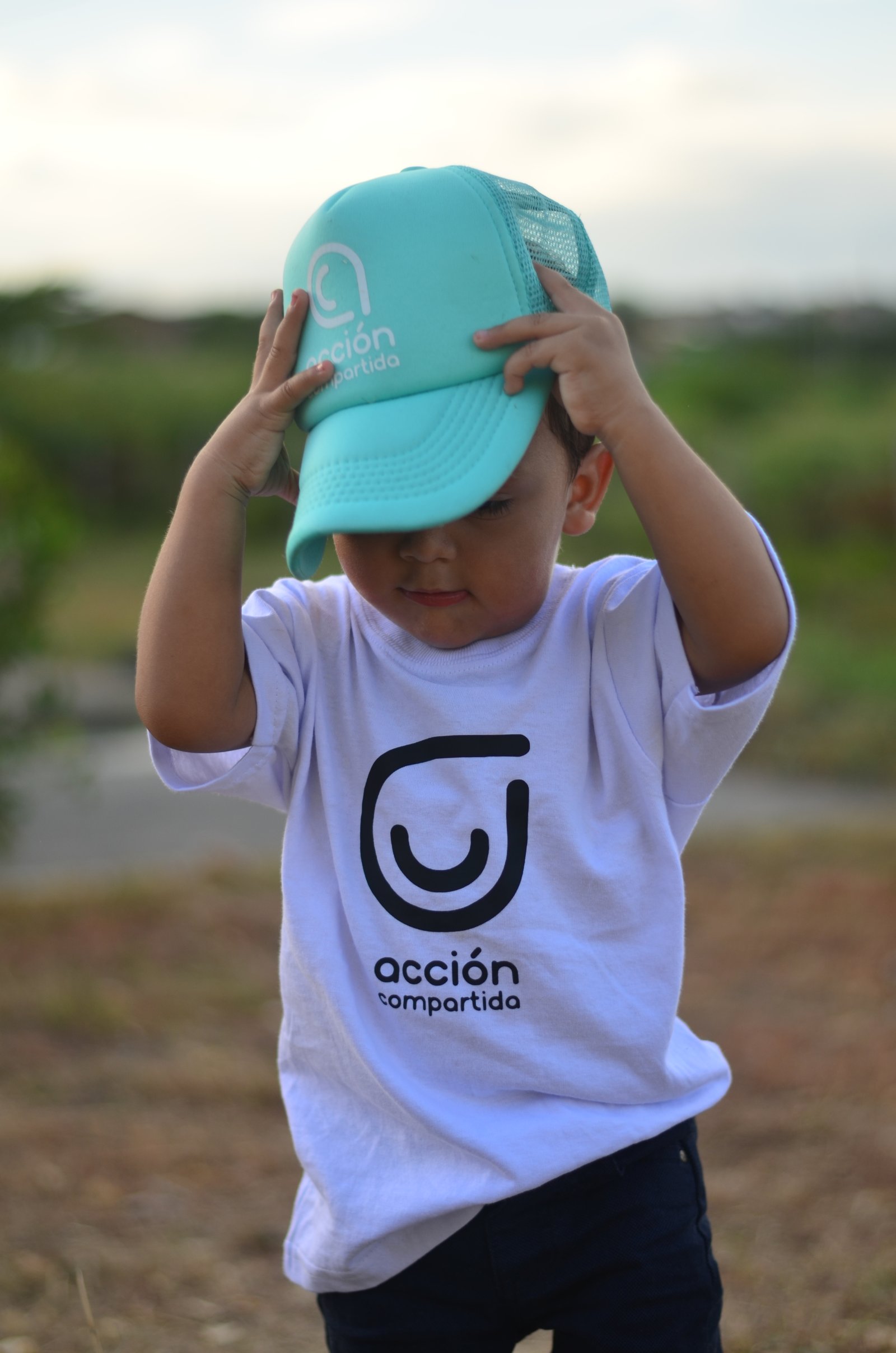 Niño con la gorra de Acción Compartida
